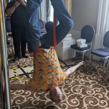 A person suspended upside-down with arms outstretched